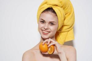 de bonne humeur femme avec à nu épaules des oranges dans le mains de agrumes peau se soucier vitamines santé photo