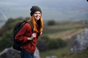 femme promeneur avec une sac à dos des promenades le chien dans le montagnes dans la nature photo
