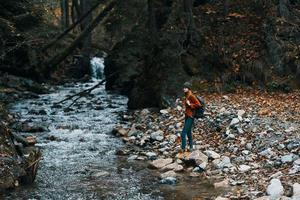 femme avec sac à dos et l'automne paysage montagnes forêt clair l'eau rivière photo