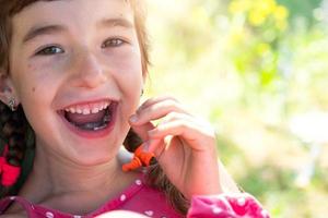 édenté content sourire de une fille avec une déchue inférieur Lait dent fermer. en changeant les dents à molaires dans enfance photo