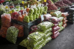 piles de le Chili poivrons, emballé dans Plastique Sacs pour vente dans le marché. photo