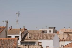 Contexte avec Espagnol carrelé toits de Maisons contre une sans nuages bleu ciel photo