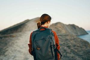 femme avec sac à dos sur sa retour rocheux montagnes paysage mer Voyage photo