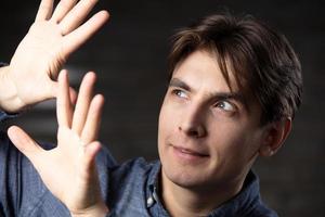 une homme spectacles gestes avec le sien mains. photo