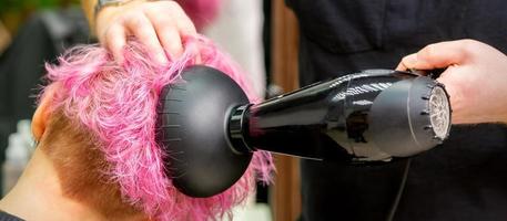 coiffeur séchage rose cheveux de client photo