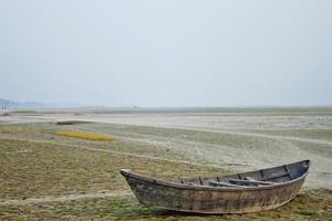 une en bois bateau sur le banque de le sec rivière à dacca, Bangladesh. photo