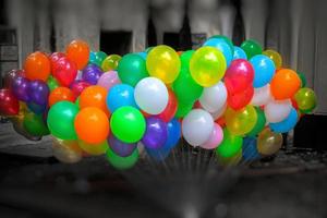 une bouquet de coloré rempli de gaz des ballons sur foncé Contexte. photo