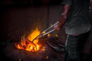 peu sûr ouvrier mains. une local acier machine les pièces fabrication Cour ouvrier fusion ferraille sur chaud fourneau. photo