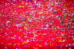 or ou argent Plastique lacets couverture sur le rouge tapis. rouge briller texture abstrait Contexte. photo