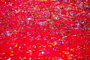 or ou argent Plastique lacets couverture sur le rouge tapis. rouge briller texture abstrait Contexte. photo