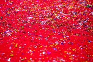 or ou argent Plastique lacets couverture sur le rouge tapis. rouge briller texture abstrait Contexte. photo