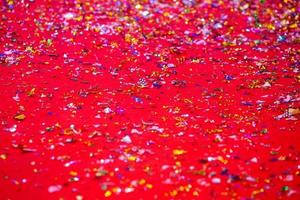 or ou argent Plastique lacets couverture sur le rouge tapis. rouge briller texture abstrait Contexte. photo