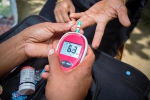 femme vérification sucre niveau avec glucomètre en utilisant une du sang échantillon à Narsingdi, Bangladesh. apprendre à utilisation une glucomètre. concept de Diabète traitement. photo