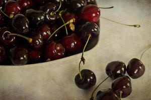 l juteux Frais été cerises dans une blanc bol sur une vintage Contexte photo