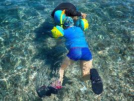 garçon plongée dans le mer dans bleu l'eau sur une été chaud vacances journée photo