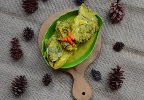 gulai képala kakap ou vivaneau poisson diriger, cuit dans curry assaisonnement, il goûts épicé, acide et sarriette. traditionnel padang cuisine, Ouest Sumatra, Indonésie. photo