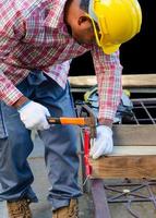 homme martelage une clou dans le en bois planche photo