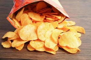 croustilles de pommes de terre dans un sac ouvert, délicieux assaisonnement pour barbecue épicé pour les frites, collations frites en tranches fines de restauration rapide. photo