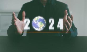 Terre journée Nouveau année 2024 économie le planète Terre concept, homme en portant nombre et glob, vert environnement, éléments de cette image meublé par nasa photo