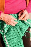 vieux femme avec tricot aiguilles et la laine photo