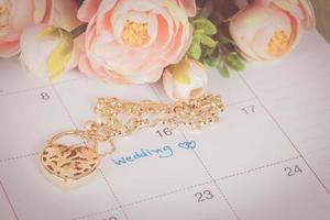 mot mariage sur calendrier et or bracelet avec cœur photo