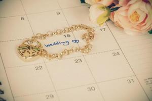 mot mariage sur calendrier et or bracelet avec cœur photo