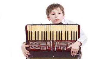 enfant avec une musical instrument. élémentaire âge garçon avec un accordéon. photo