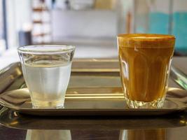 un café tasse et en buvant l'eau mis sur une en bois tableau, dans une café café magasin les boissons sont disponible. chaud à l'intérieur pour à emporter prêt à boire, rafraîchissant. arôme éveillé Frais à travail mis photo