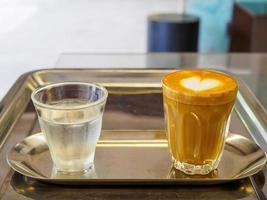 un café tasse et en buvant l'eau mis sur une en bois tableau, dans une café café magasin les boissons sont disponible. chaud à l'intérieur pour à emporter prêt à boire, rafraîchissant. arôme éveillé Frais à travail mis photo