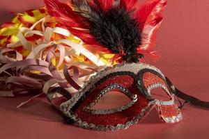 masque de carnaval vénitien avec plumes et éléments typiques en arrière-plan photo