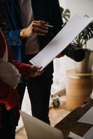 trois collègues discutant du travail des données et de la tablette, ordinateur portable avec sur le projet architectural sur le chantier de construction au bureau au bureau photo