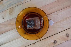 sachet de thé dans verre sur en bois table photo