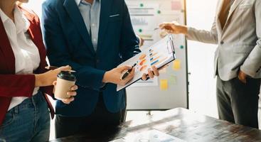 homme d'affaires et équipe analysant la tâche de financement des états financiers. avec téléphone intelligent et ordinateur portable et tablette. notion de gestion de patrimoine photo