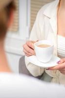 Jeune caucasien méconnaissable femme en portant une tasse de chaud boisson à une médecins rendez-vous dans hôpital bureau. photo