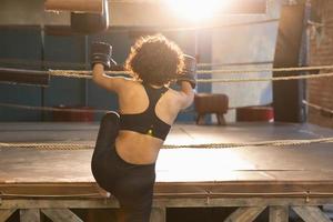 femmes soi la défense. africain femme combattant en train de préparer pour compétition bats toi Aller à boxe anneau. fort fille prêt pour bats toi actif exercice sparring faire des exercices entraînement. formation journée dans boxe salle de sport. photo