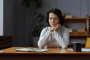 triste fatigué mauvais malade solitaire déçu plus âgée Sénior femme séance à Accueil seule. malheureux mature grand-mère expérience douleur relatif décès mal nouvelles. stressé aîné Dame Souffrance de solitude. photo