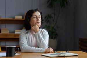 triste fatigué mauvais malade solitaire déçu plus âgée Sénior femme séance à Accueil seule. malheureux mature grand-mère expérience douleur relatif décès mal nouvelles. stressé aîné Dame Souffrance de solitude. photo