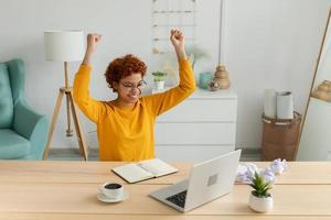 excité content africain américain femme gagnant. fille femelle étudiant à la recherche à portable réussi examen en train de lire génial nouvelles avoir bien résultat gagnant en ligne offre sentiment étonné à la recherche à ordinateur à maison. photo