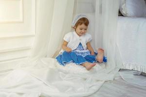 mignonne peu fille en jouant dans lumière blanc chambre photo