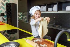 peu fille en train de préparer pâte, cuire fait maison vacances Pomme tarte dans cuisine photo