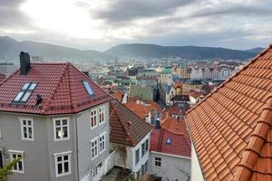 charmant Maisons avec une carrelé toit contre le toile de fond de montagnes et brouillard dans Norvège photo