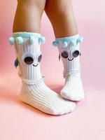 bébé chaussettes avec yeux et sourire sur rose Contexte photo