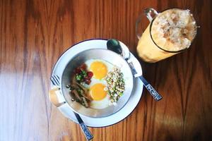 Indochine poêlé Oeuf avec garnitures dans fait maison thaïlandais style avec la glace café sur en bois table photo