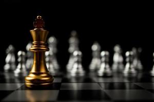 échecs du roi d'or debout devant d'autres échecs, le concept d'un leader doit avoir du courage et du défi dans la compétition, le leadership et la vision commerciale pour gagner dans les jeux d'entreprise photo