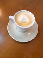 café dans une blanc Coupe. blanc tasse avec café sur une en bois surface photo