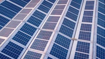 une grand solaire cellule toit sur un industriel bâtiment générateur électricité pour le plante pendant jour selon à Stratégies et les mesures à réduire global chauffage par prise grand angle coups de drones photo