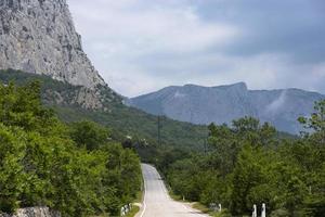 une pavé route le long de rocheux montagnes avec une dangereux courbe. paysage. photo