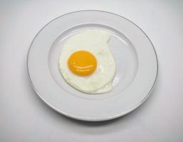 ensoleillé côté en haut Oeuf servi dans blanc assiette isolé dans blanc Contexte photo