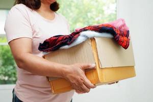 dons de vêtements dans une boîte en carton pour les bénévoles. photo