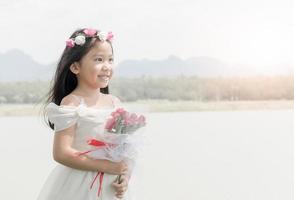 mignonne peu la mariée tenir Rose bouquet sur la nature Contexte photo